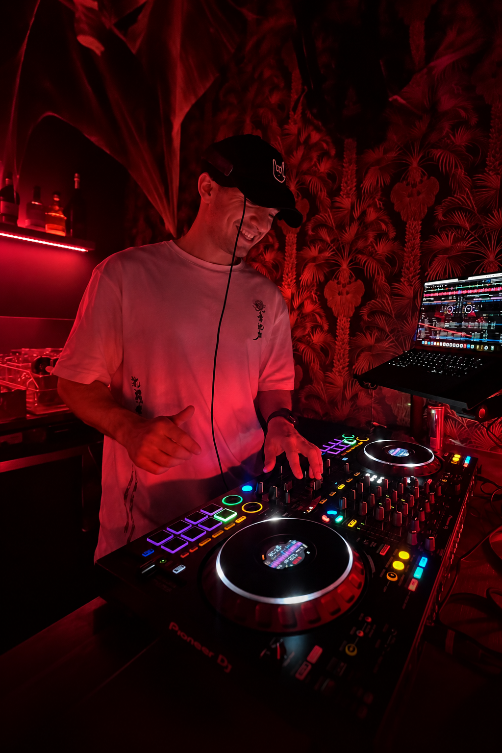 DJ Cuezar als DJ & Producer am Controller bei rotem Clublicht
